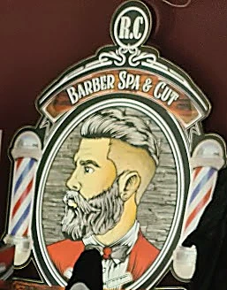 Emblema ovalado de la pared: R.C. Barber Spa & Cut, con un barbero de barba y postes a los lados